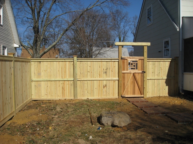 Custom made flat board fence with bottom and top trim board on 6 x 6 posts